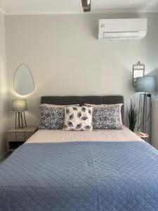 a bedroom with a bed with a blue comforter and pillows at Blooming 31 AXD in Alexandroupoli