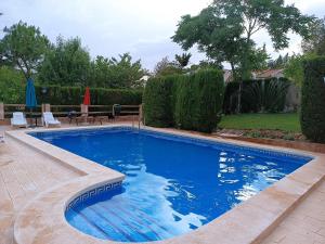 a swimming pool with blue water in a yard at La Cabaña de Piedra in Ruidera