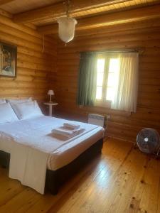 une chambre avec un lit dans une cabane en rondins dans l'établissement Villa Katia, à Agiokampos