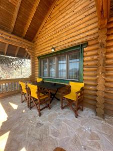 Cette cabane en bois dispose d'une terrasse avec une table et des chaises. dans l'établissement Villa Katia, à Agiokampos