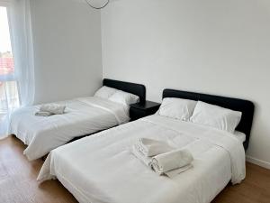 due letti uno accanto all'altro in una stanza di Charmant 2 Pièces avec Parking Près de Paris by Immo Kit BNB a La Courneuve