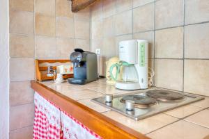 a kitchen counter with a coffee maker on a stove at Chambres d'hôtes les Hautes Papinières in Saint-Prouant