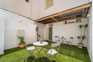 an apartment patio with grass and a table and chairs at La Siesta de Picasso in Málaga