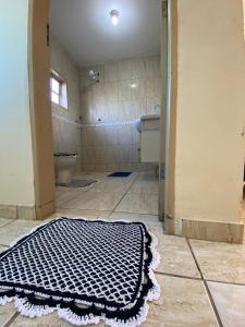 a bathroom with a black and white rug on the floor at Elache Plaza Hotel in Roseira