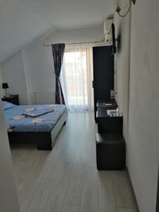 Un dormitorio con una cama y un escritorio y una ventana. en Casa Debora, en 2 Mai