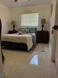 Un dormitorio con una cama y dos lámparas y una ventana. en Ludge by Miami Airport, en Miami