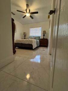 Un dormitorio con una cama y un ventilador de techo. en Ludge by Miami Airport, en Miami
