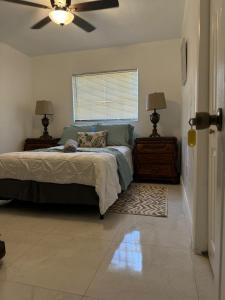 Un dormitorio con una cama y un ventilador de techo. en Ludge by Miami Airport, en Miami