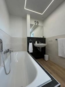 a bathroom with a large tub and a sink at Geschmackvolle moderne Apartment-Wohnungen in Hünfeld