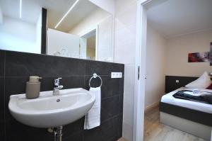 a bathroom with a sink and a bed at Geschmackvolle moderne Apartment-Wohnungen in Hünfeld +32 photos