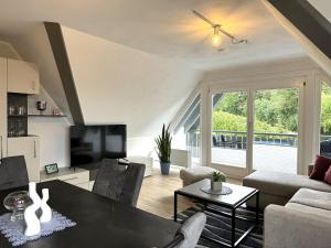 a living room with a table and a television at Geschmackvolle moderne Apartment-Wohnungen in Hünfeld