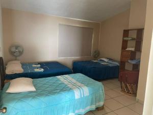 Habitación con 2 camas y ventilador. en La Casa del Risco, en Lázaro Cárdenas