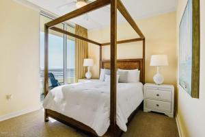 a bedroom with a canopy bed with a view of the ocean at Ocean Front Paradise in Biloxi +12 photos