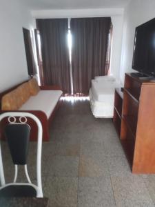 a living room with a couch and a tv at Via Venetto Flat in Fortaleza