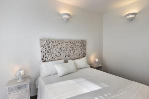 a white bedroom with a white bed and two night stands at MARIMAR - Apartments OTRANTO in Otranto