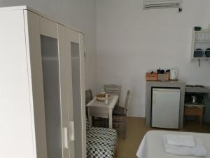 a room with a bed and a table and a kitchen at Thalassa3 in Andros