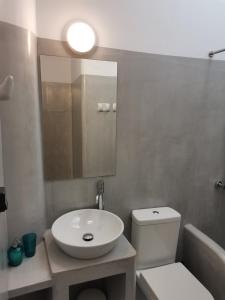 a bathroom with a sink and a toilet and a mirror at Thalassa3 in Andros