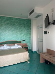 a bedroom with a bed and a green wall at Hotel America in Marina di Camerota