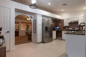 a kitchen with white cabinets and a stainless steel refrigerator at The Triple Palms in Kingman