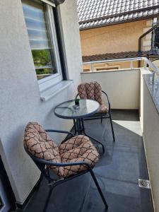 a patio with two chairs and a table on a balcony at Apartman Curcic 1 in Soko Banja +4 photos