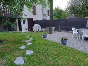 a backyard with a table and chairs and a fence at L'entre deux in Entrelacs