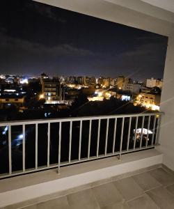 a balcony with a view of a city at night at Vi Hosting Anzoategui Aparts in Salta