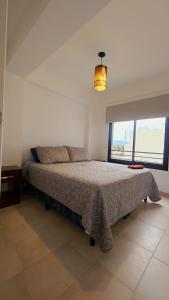 a bedroom with a bed and a large window at Vi Hosting Anzoategui Aparts in Salta