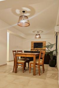 a dining room with a wooden table and chairs at Vi Hosting Anzoategui Aparts in Salta
