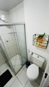 a bathroom with a toilet and a glass shower at Apartamento sofisticado com piscina e vista privativa in Ilhéus