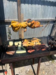 a grill with meat and other food on it at Yorulmaz Forest in Buhoci +3 photos