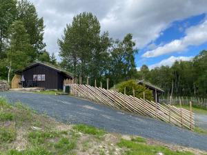 a barn and a fence next to a road at Rauland Hytteutleige in Rauland