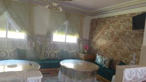 a living room with a couch and a table at Appartement dawdi ras el ma in Ras El Ma