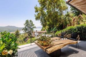 バジェ・デ・ブラボにあるCasa Sol In Avándaro with jacuzzi and lake viewのパティオ(木製ベンチ、バルコニーの椅子付)