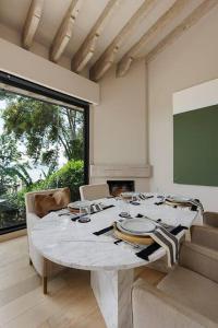 バジェ・デ・ブラボにあるCasa Sol In Avándaro with jacuzzi and lake viewの白いテーブルとスクリーンのあるダイニングルーム