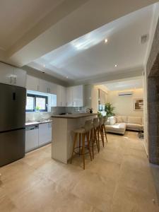 a kitchen with white cabinets and a bar with stools at Stone Crafted Luxury Villas in Nikiana