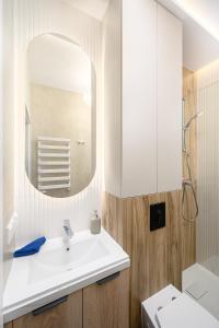 a bathroom with a white sink and a mirror at Quiet Apartment on the Main Square, 2 Bathrooms in Wrocław