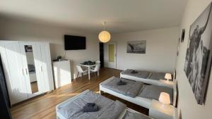 リューデンシャイトにあるGroße Wohnung mit 7 Betten, große Küche, Balkonのベッド2台とテーブルのあるリビングルーム