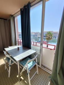 ein Tisch und ein Stuhl in einem Zimmer mit Fenster in der Unterkunft Studio cabine climatisé sur le port de Mèze in Mèze