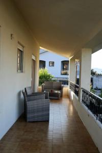 a porch with two chairs and a couch on a house at Casa Familiar - Espaçosa, confortável e sossegada in Pevidem