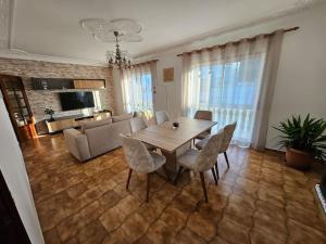 a living room with a wooden table and chairs at Casa Familiar - Espaçosa, confortável e sossegada in Pevidem