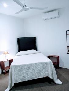 - une chambre blanche avec un lit blanc et 2 tables dans l'établissement Casa bonita, à Francisco Uh May