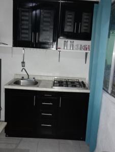 une cuisine avec un évier et une cuisinière dans l'établissement Casa bonita, à Francisco Uh May