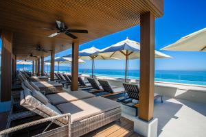 una fila de sillas y sombrillas en una playa en 6th-Floor Amapas Retreat – Pool & Sunset Views, en Puerto Vallarta