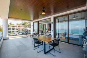 una sala de estar de planta abierta con mesa de madera y sillas. en 6th-Floor Amapas Retreat – Pool & Sunset Views, en Puerto Vallarta