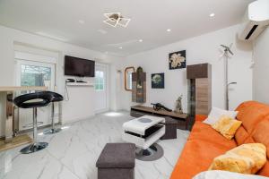 a living room with a orange couch and a stool at Ley in Bribir
