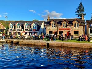 a group of houses next to a body of water at Erraid Lodge in Fort Augustus