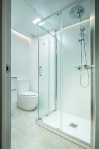 a glass shower in a bathroom with a toilet at Bcn - Loft Parc Guell in Barcelona