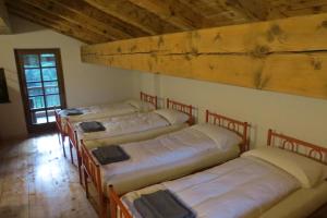 a group of four beds in a room at Baita Misonet in Comano Terme +13 photos