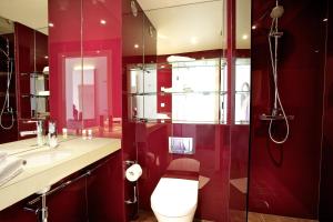 Baño rojo con aseo y lavamanos en Hotel Smartino en Schwäbisch Hall