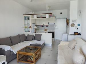 a living room with a couch and a table at Seafront Apartment Pefkochori in Pefkochori
